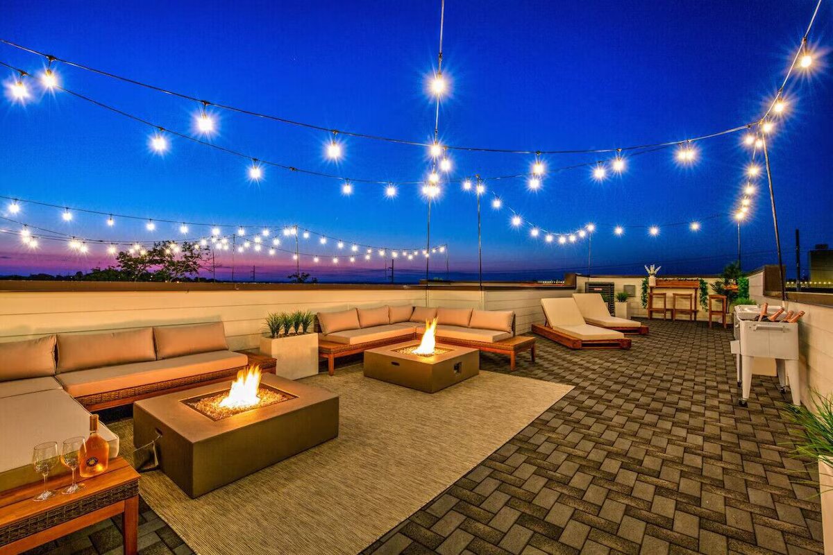 Nashville rooftop deck at twilight with string lights and fire pits